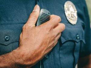 A police officer in uniform holding a radio communicator, showcasing professional authority.